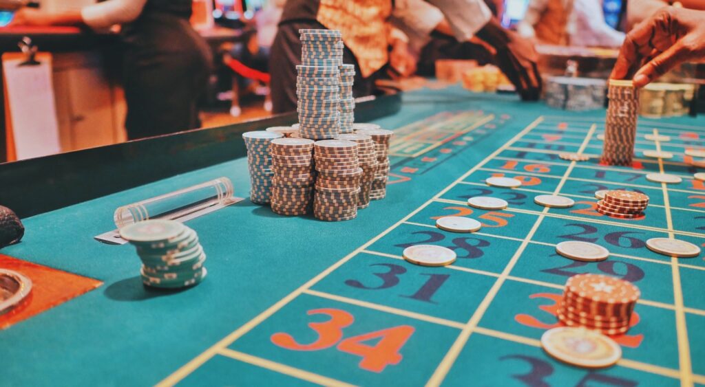 Stacks of chips on a roulette table in a busy casino