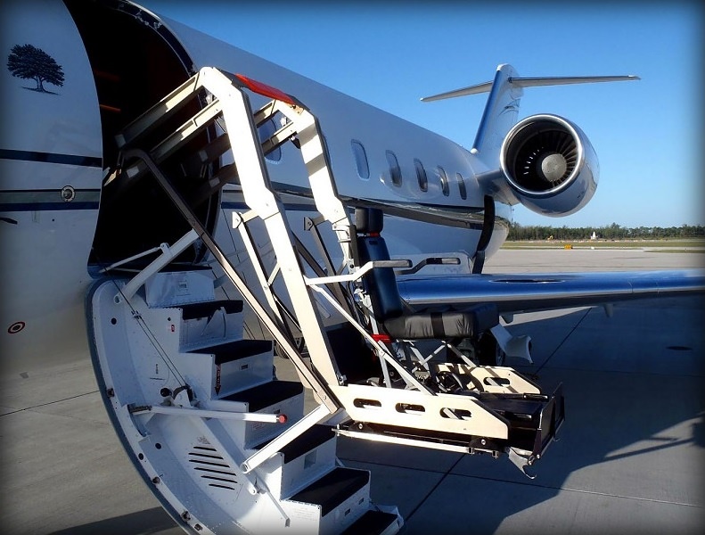 Wheelchair lift raising a passenger to the door of a private jet for a Colorado charter flight